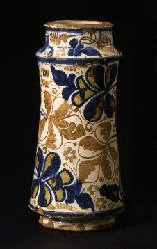 Albarello af lergods bemalet med blåt i og med lustre over en opak, hvid glasur.